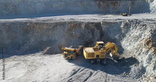 Quarry mining, work of the excavator on open mine pit, aerial slow motion shot