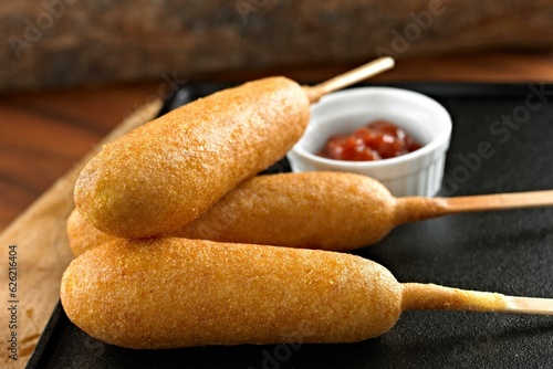 Classic Fair Delight: Close-Up of a Corn Dog Served with Ketchup on a Wooden Background, Tempting Your Taste Buds in 4K Resolution
