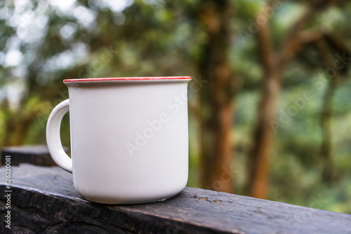 Skillfully arranged for mockup use, the image presents a white blank mug, blending seamlessly with the natural surroundings, creating a stunning visual