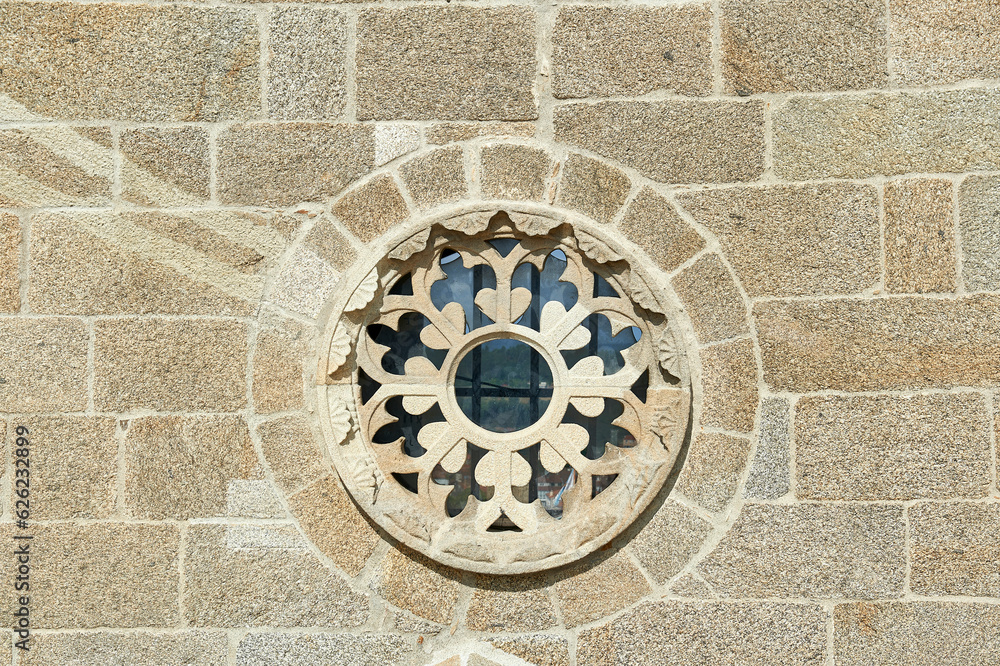 rose window with vegetal decoration on the granite wall