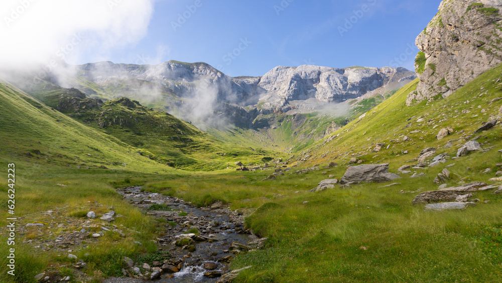 Mountain landscape with a river comming from the mountains at the background on a sunny day Mountain landscape with a river comming from the mountains at the background on a sunny day