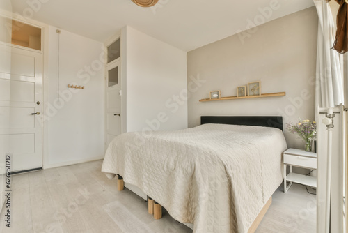 a bedroom with white walls and wood flooring the room has a large bed, wooden shelves on either side