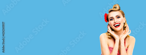 Fototapeta Naklejka Na Ścianę i Meble -  Portrait photo of excited surprised, very happy beautiful blond woman. Pin up girl with open mouth and raised hands showing toothy smile. Retro vintage concept. Mock up bright blue color background.
