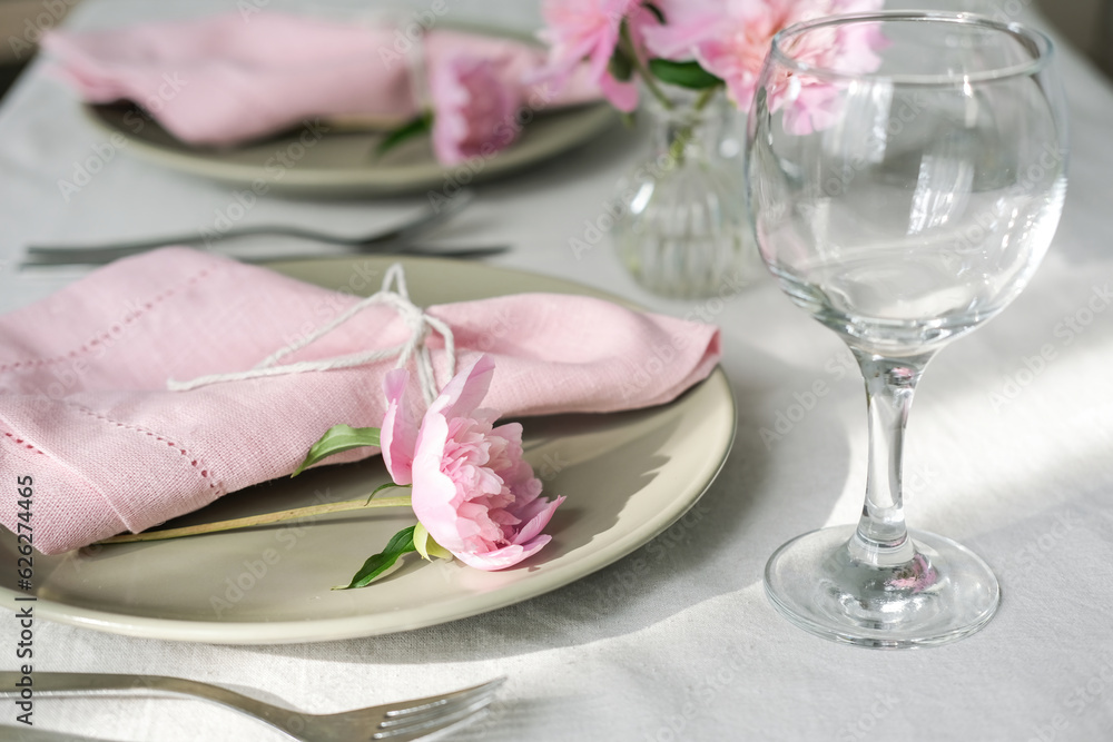 Table setting with light green ceramic plates and pink peonies Table setting with light green ceramic plates and pink peonies