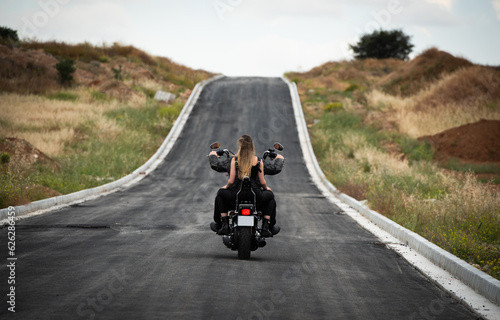 Sexy woman wearing with blonde long hair riding a street motorbike outdoors. Exploration  journey  adventure, street bike
