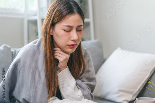Canvas Print Sick young woman touching her neck and feeling pain inside the throat effect after coughing too much from influenza in winter season