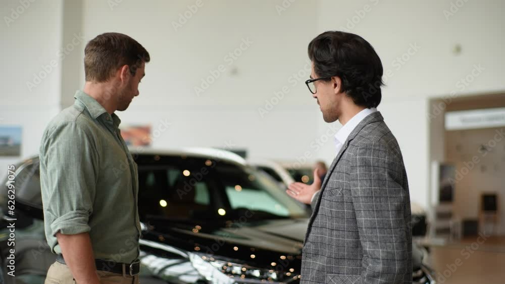 Portrait of professional salesman in business suit shaking client hand