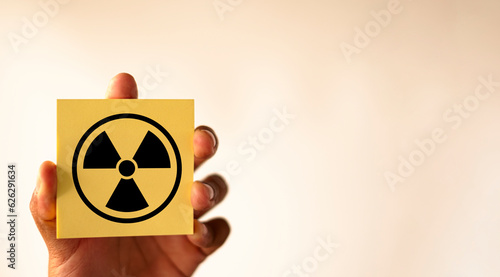 Attention symbol,Cautionary Warning,safety, hazard,danger concept.,Radiation hazard sign on yellow sticky note over white background with copyspace use for Nuclear,radioactive alert warning idea.