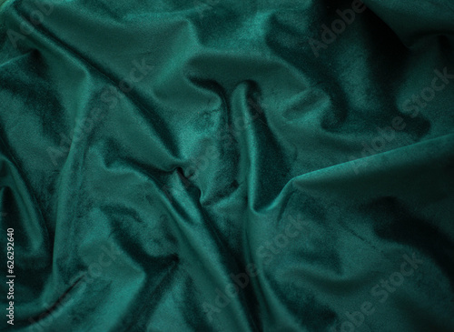 emerald velvet with folds background image, green shiny fabric silk for background web design wallpaper, dark green textile background