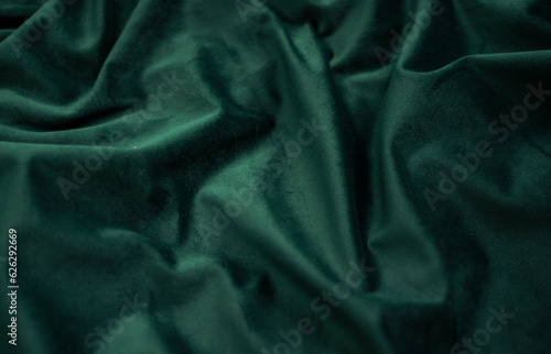 emerald velvet with folds background image, green shiny fabric silk for background web design wallpaper, dark green textile background