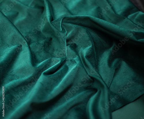 emerald velvet with folds background image, green shiny fabric silk for background web design wallpaper, dark green textile background