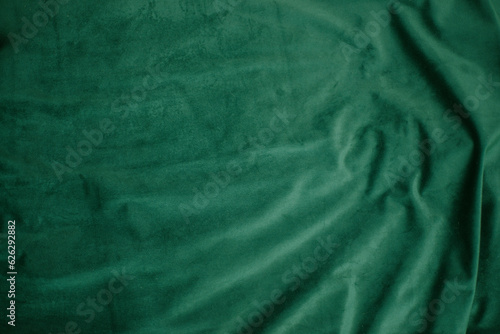 emerald velor with folds background image, green shiny fabric silk for background web design wallpaper, dark green textile background