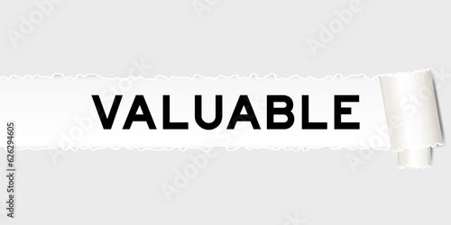 Ripped gray paper background that have word valuable under torn part