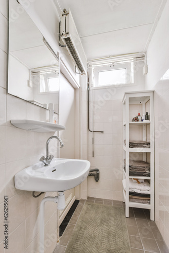 a small bathroom with a sink and towel rack in the corner, while it's not visible on the wall