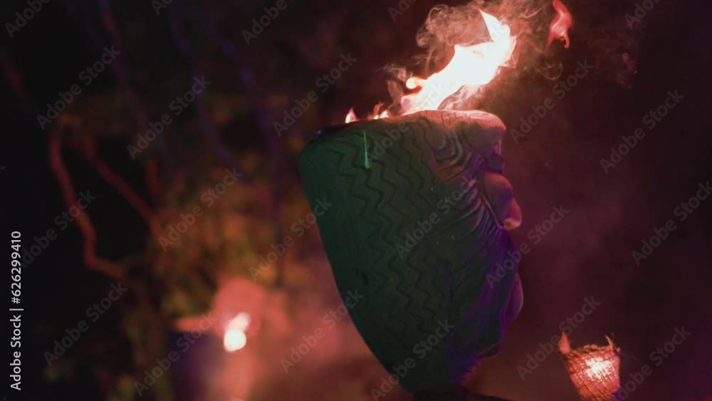 Burning torches and totems at a nighttime fire show performance Burning torches and totems at a nighttime fire show performance