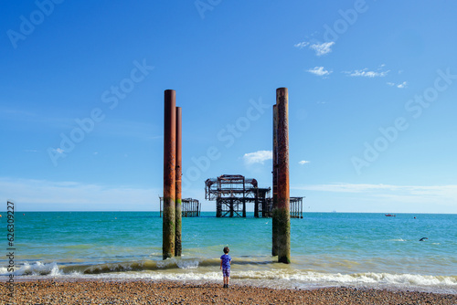 boy looking out to sea at destroyed pier © jay