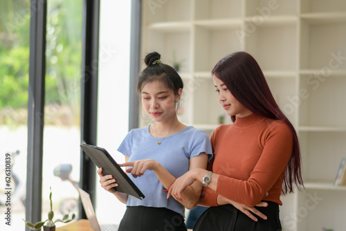 Two young freelance businesswoman discuss management planning. new startup project ideas planning and statistics and the investment market at the office © Wasana