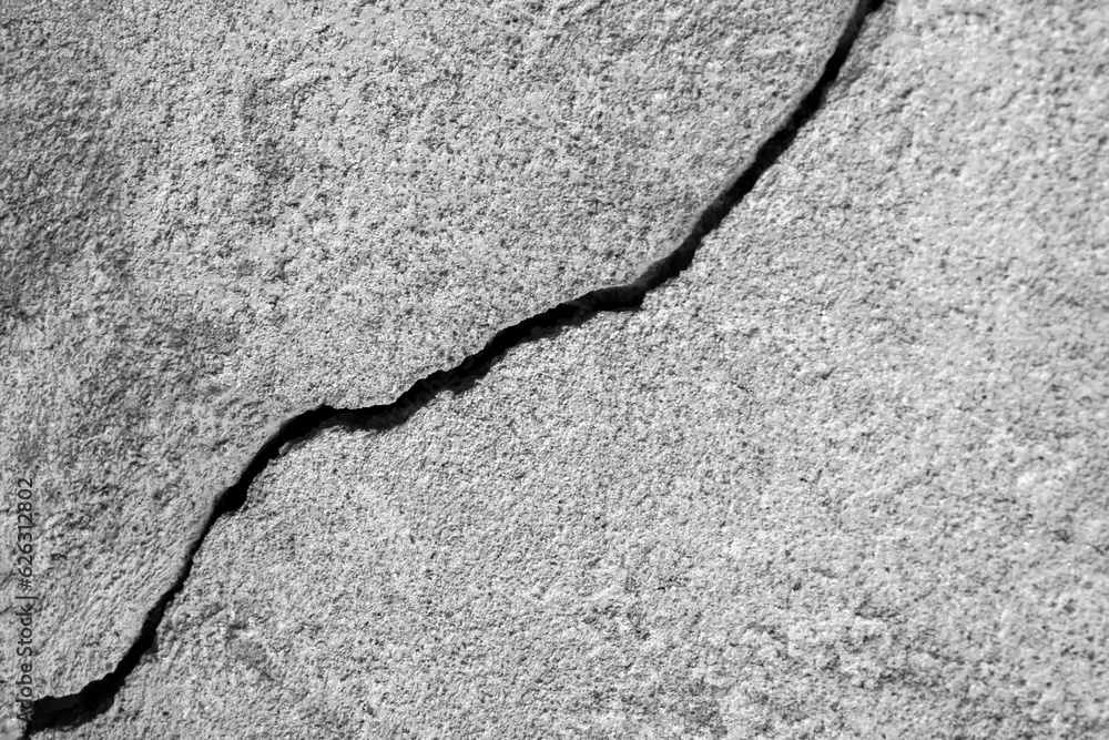 Obraz premium Big long winding ascending crack on old plastering wall. Copy space. Black and white photo. Selective focus.