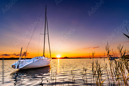 łódka na jeziorze o zachodzie słońca © FotoWave Dawid Nowak