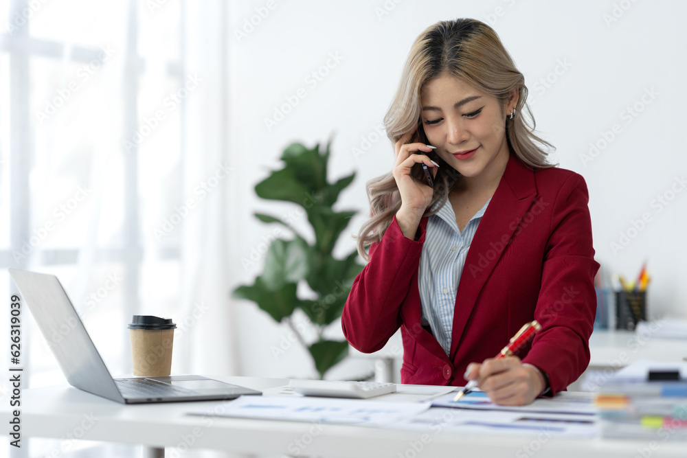 Attractive Asian businesswoman using mobile phone to search, contact, chat, business negotiations with customers. Online paperwork at office desk. Attractive Asian businesswoman using mobile phone to search, contact, chat, business negotiations with customers. Online paperwork at office desk.