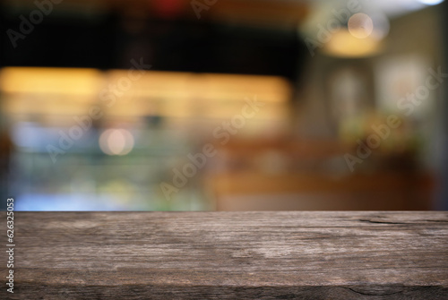 Empty dark wooden table in front of abstract blurred bokeh background of restaurant. can be used for display or montage your products.Mock up for space.
