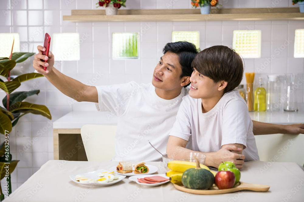 Young LGBT Asian gay couple selfie or video call during eat