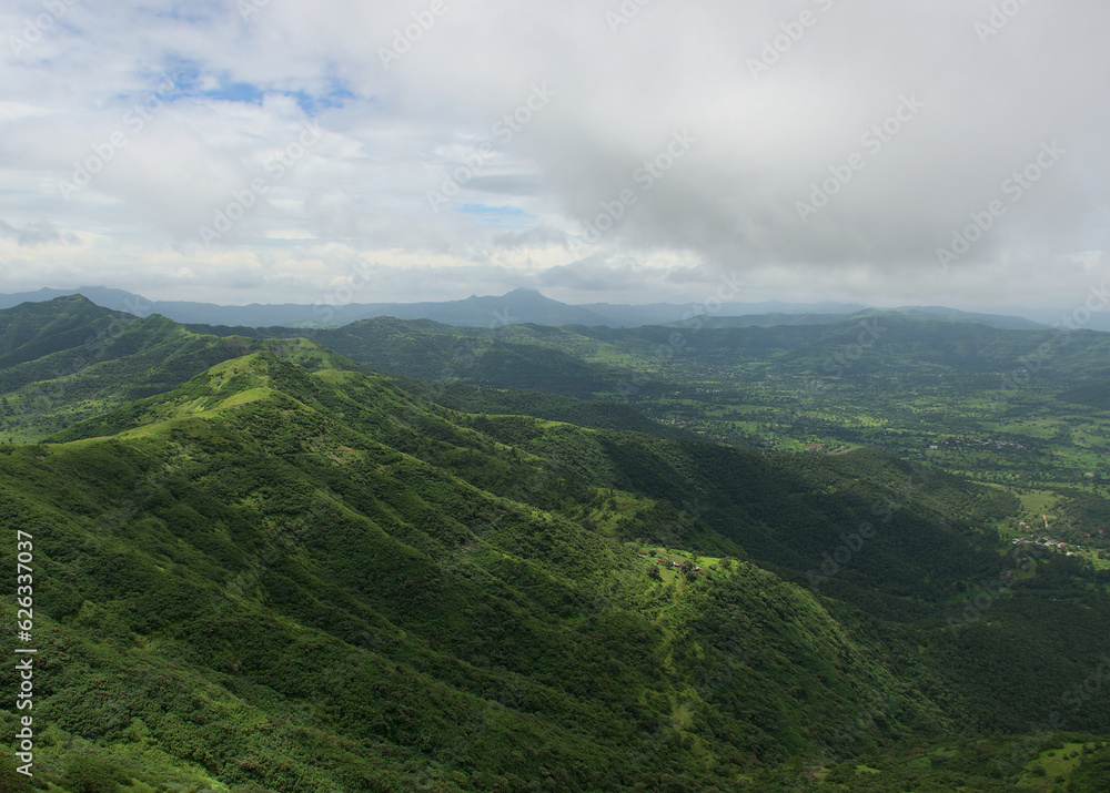 Panoramic landscape view of beautiful lush green Sahyadri mountains in monsoon season as seen from Sinhgad fort located in Pune, Maharashtra, India