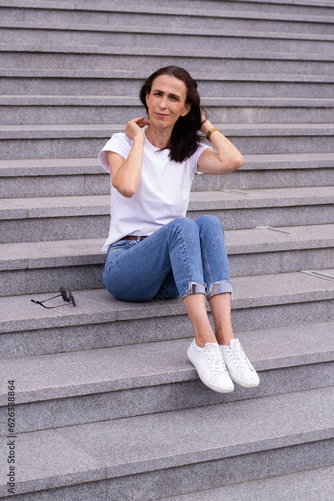 Woman is sitting on the stairs outdoors Woman is sitting on the stairs outdoors