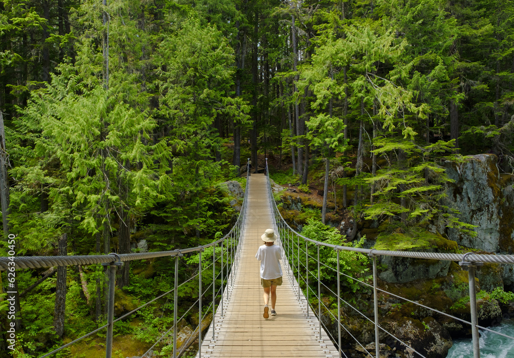 Woman in suspension bridge over Cheakamus River, Whistler, British Columbia, Canada.
