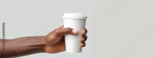 A man's hand holds a white paper coffee cup with a white lid on a white isolated background. Created with Generative AI technology.