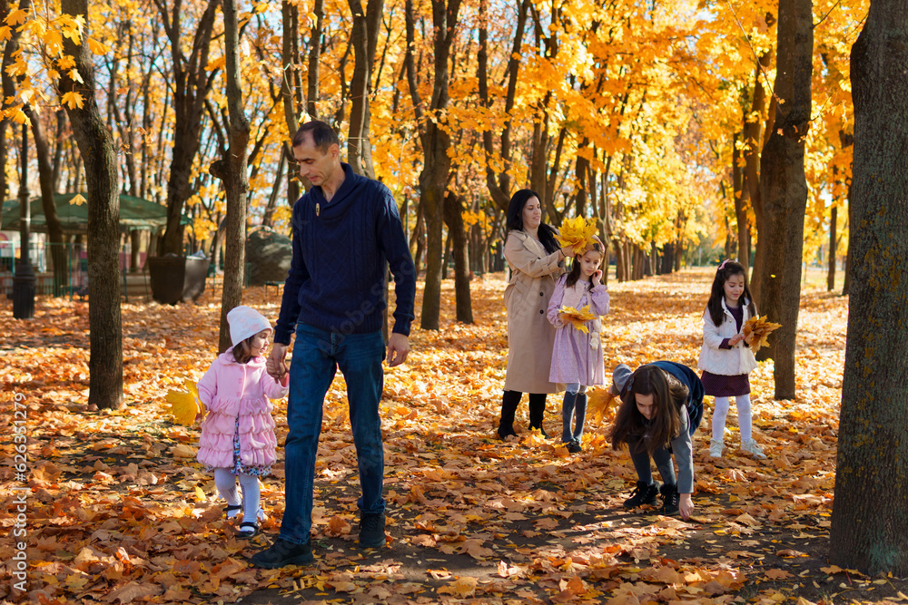 portrait of a family with children in an autumn city park, happy people walking together, playing with yellow leaves, beautiful nature, bright sunny day portrait of a family with children in an autumn city park, happy people walking together, playing with yellow leaves, beautiful nature, bright sunny day