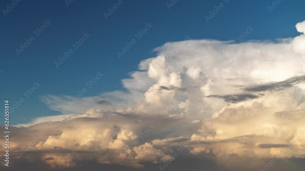 Timelapse of a large bright white cumulus cloud lit up by the sun moving towards the right isolated on a blue sky backdrop. Timelapse of a large bright white cumulus cloud lit up by the sun moving towards the right isolated on a blue sky backdrop.
