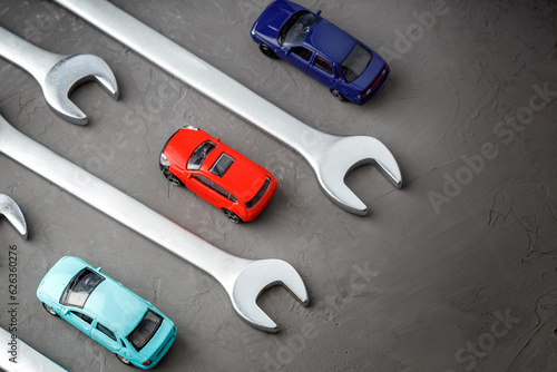hand tool wrenches and toy cars on a gray background