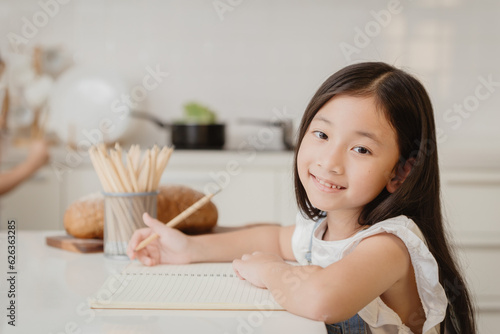 Cute child girl happy learning education doing home work at home holiday