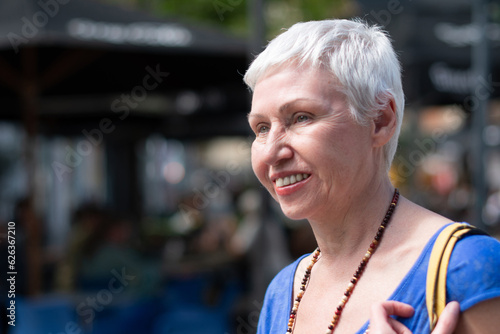 middleaged woman stylishly dressed confidently smiling on the street in the city