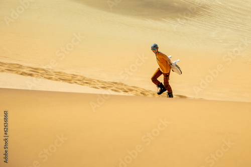 Single sand boarder climbing a dune near Swakopmund, Skeleton Coast, Namibia. 