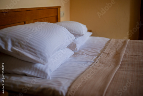 pillows on the bed in the hotel room, cozy atmosphere rest © Olga Mykovych