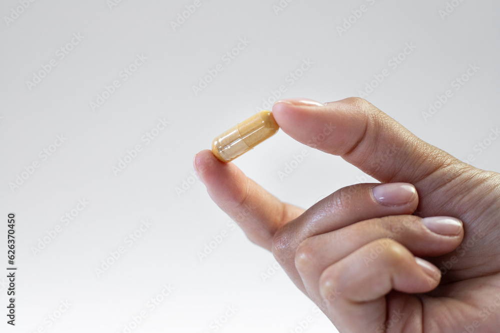 Dietary supplements capsule held in hand, healthy way of life, strengthening body and mind