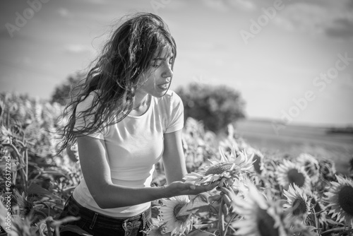 Bild auf Leinwand jeune femme dans un chambre de fleur de tournesol en noir et blanc