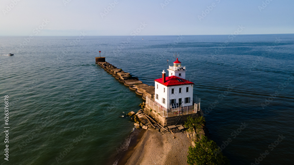Lighthouse Looking Out Over the Water at Sunset Aerial Lighthouse Looking Out Over the Water at Sunset Aerial