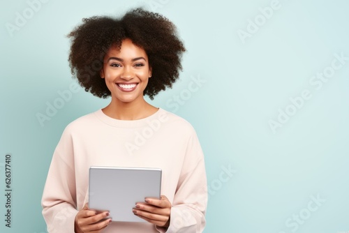 Fictional black woman smiling and holding a tablet. Isolated on a colored background. Generative AI.