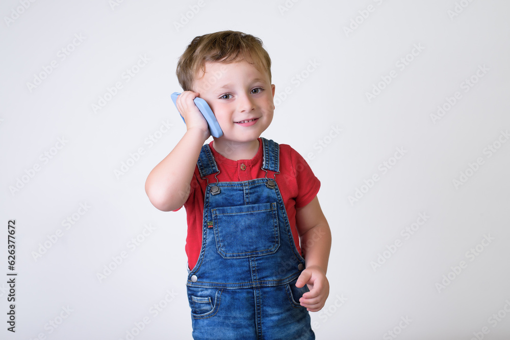 Smiling boy using cell phone isolated in white studio