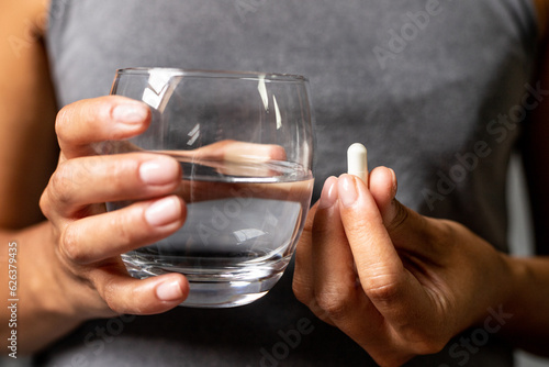 Obraz na płótnie Taking tablets with water, dietary supplements in capsules, supplementing with vitamins and minerals w salonie