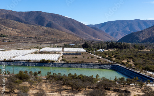 Greenhouses and a big basin filled with water for citriculture in Petorca in Chile, South America - plantation of citrus fruits photo