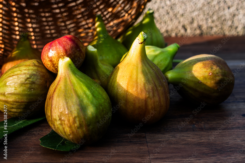 A few figs on an brown wooden background in sunshine.