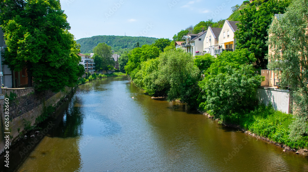 River embankment in Europe with houses and trees.