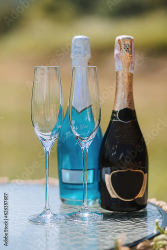 champagne bottles and glasses next to each other on the table. Blue and black champagne