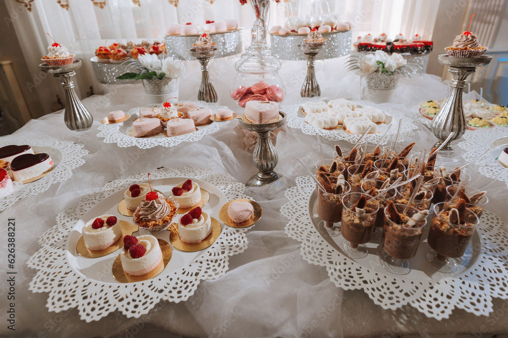 Festive dessert table with sweets. Wedding candy bar, various cakes, chocolates on stands.