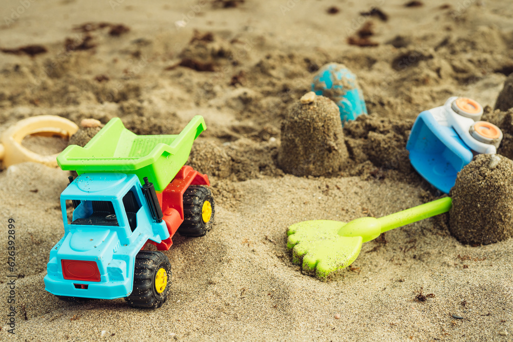 children's beach toys made of plastic on the sand near the sea trucks watering can rake children's beach toys made of plastic on the sand near the sea trucks watering can rake