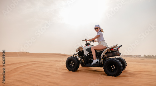 Woman riding sand dunes ATV in the Dubai desert